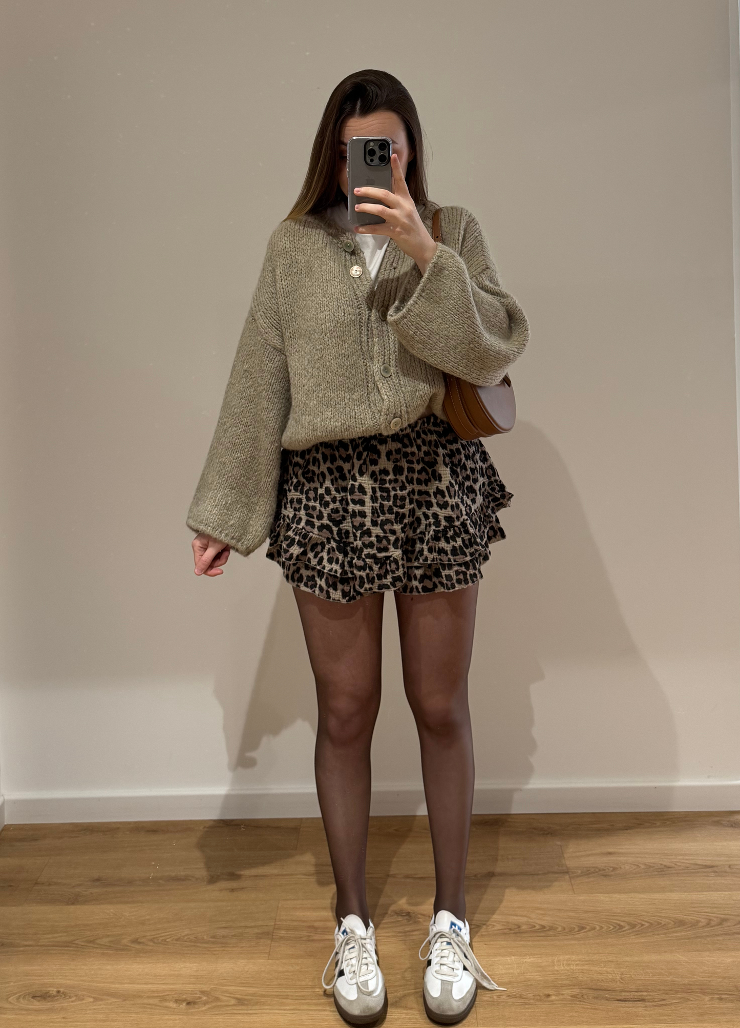 Femme portant un gilet droit beige LOU en coton à boutons argenté, avec un short à motifs léopard KLEOFINA , vue en intérieur sur parquet et fond blanc.
