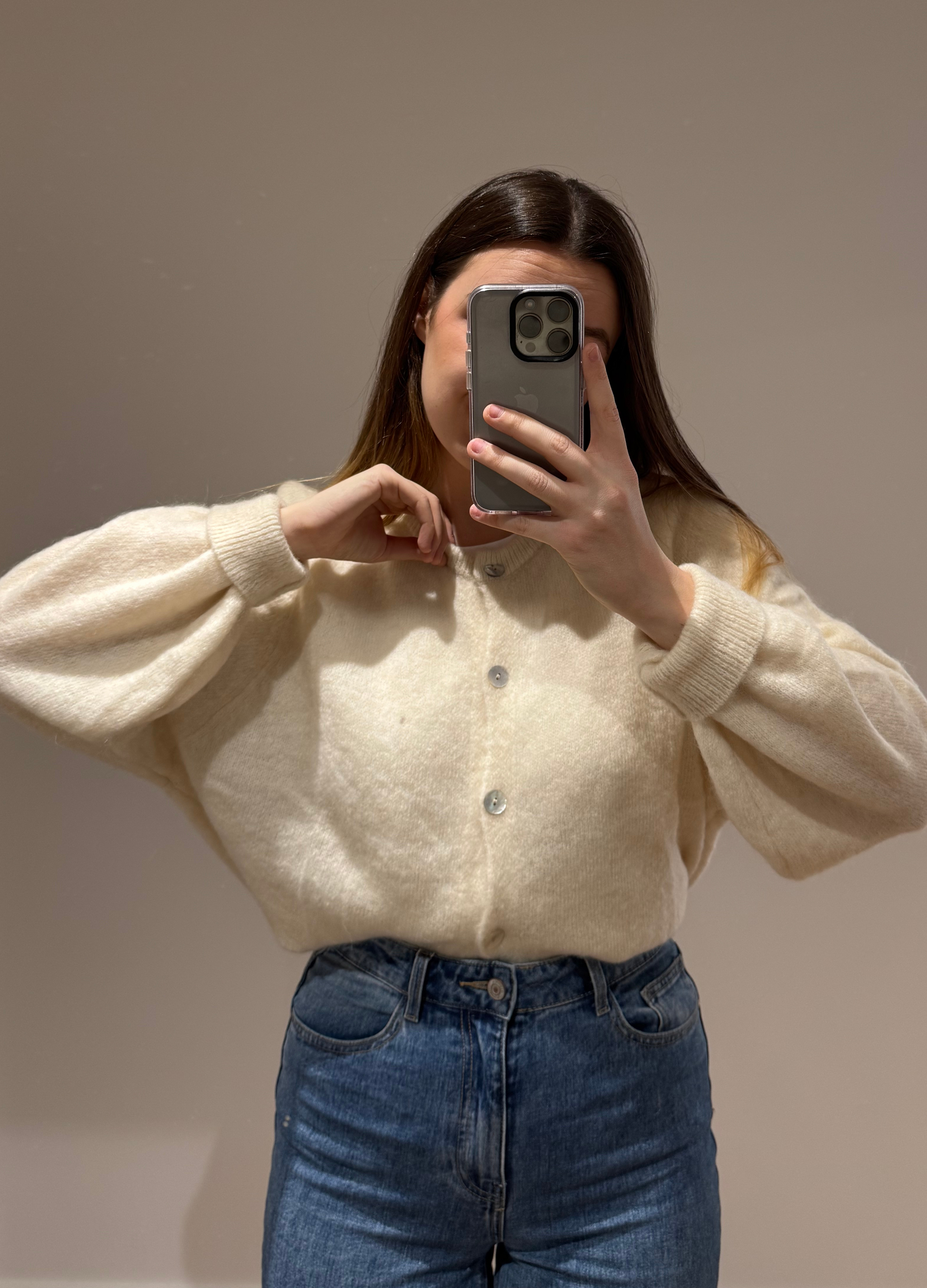 Zoom sur un cardigan blanc OLIVIA avec des boutons argentés, porté avec un jean ALEXIA, sur un fond blanc.
