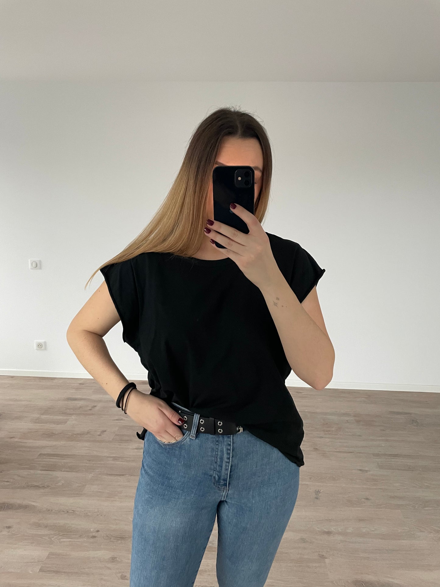 Une fille qui porte un top noir en matière 100 % Coton avec une jean bleu